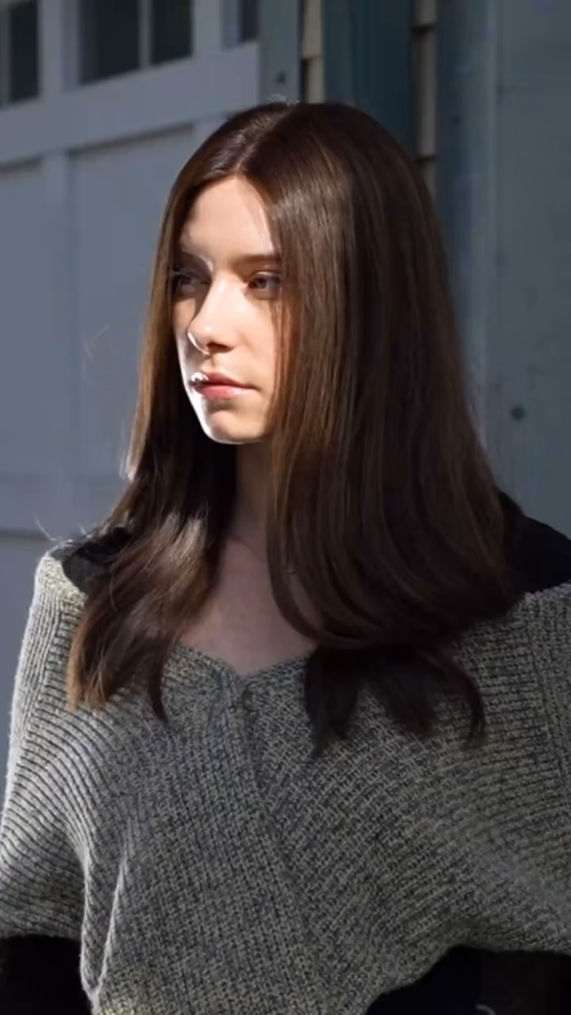 Woman with long brown hair wearing a kosher sheitel wig